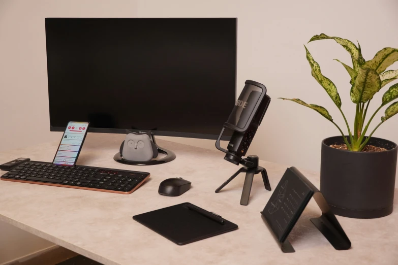 a desk with a monitor, keyboard, mouse and phone
