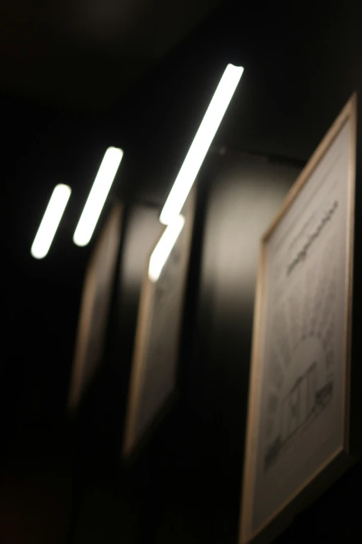 a black room with several framed pographs and lights