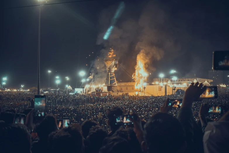 crowds watching fireworks in a large building on a hill