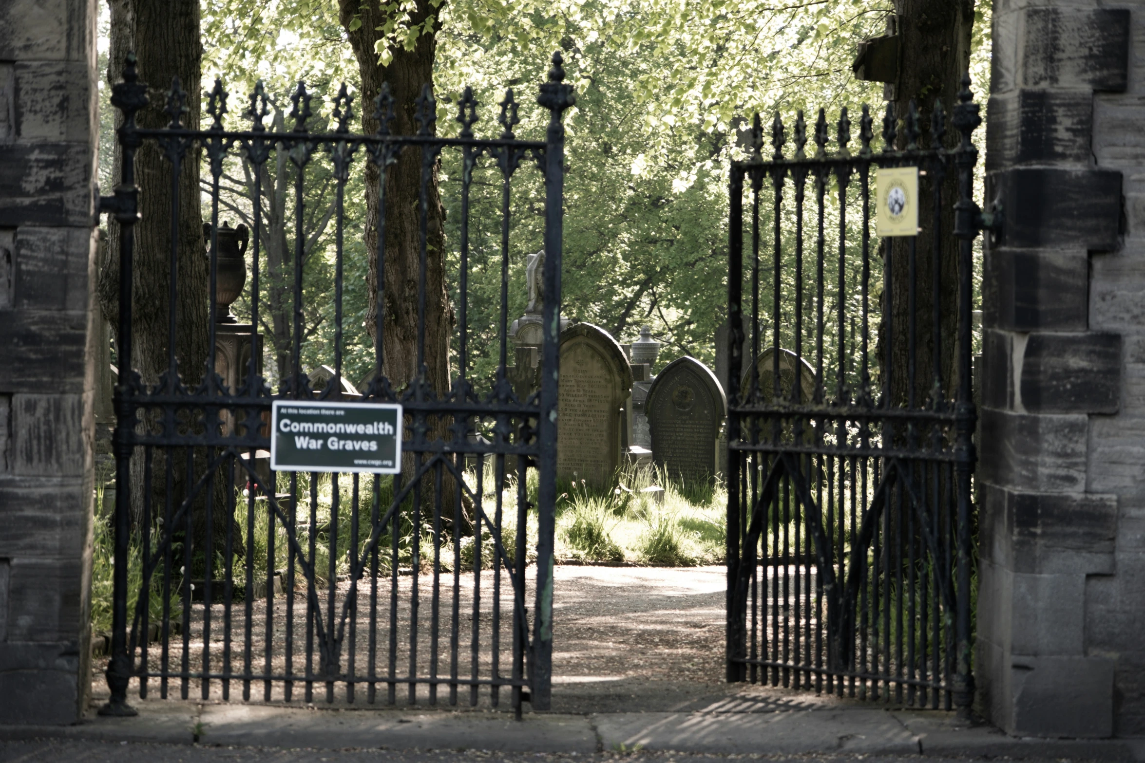 the gated entry into a cemetery is open