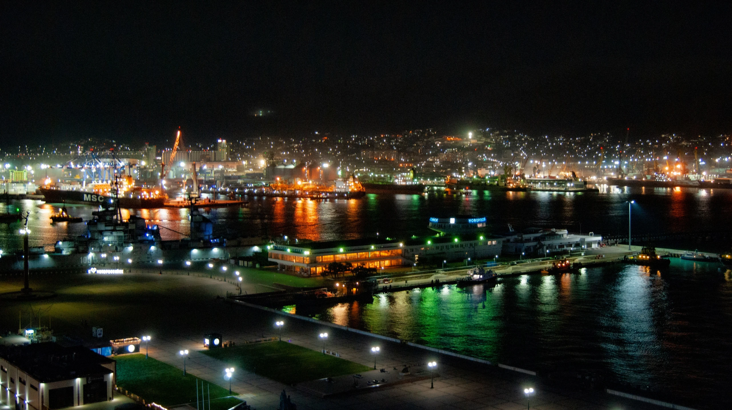 city lights reflecting off the water at night