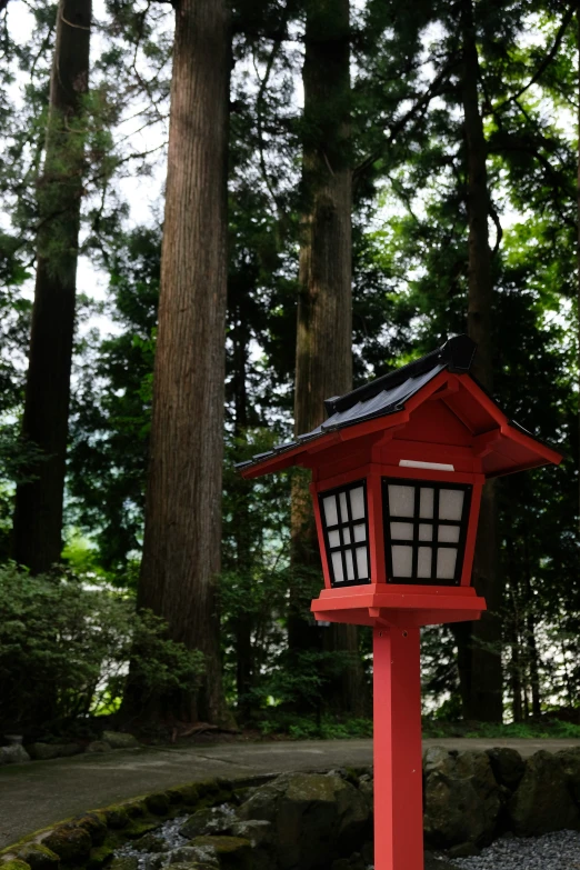 a red and white lamp by some trees