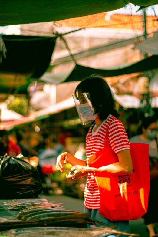 woman with face mask standing near vegetable market