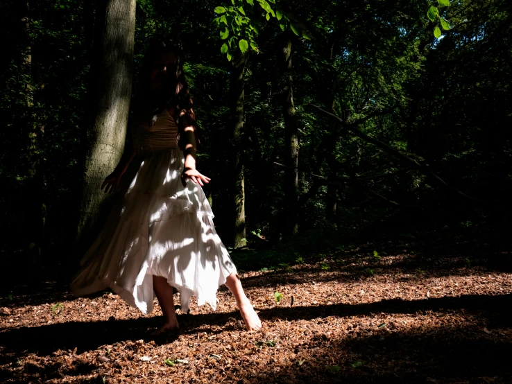 a woman is standing outside with her dress flowing