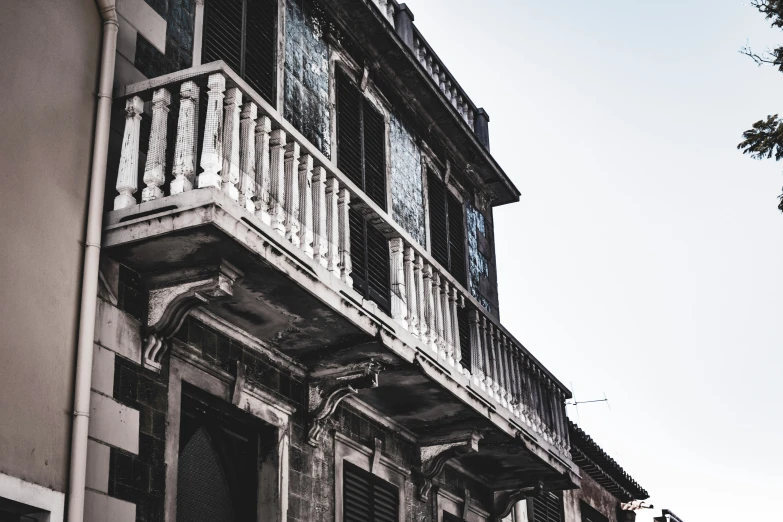 an old looking building with wrought iron balcony