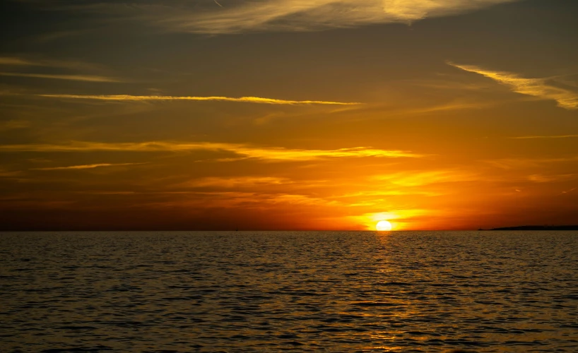 an orange and black sunset in the ocean