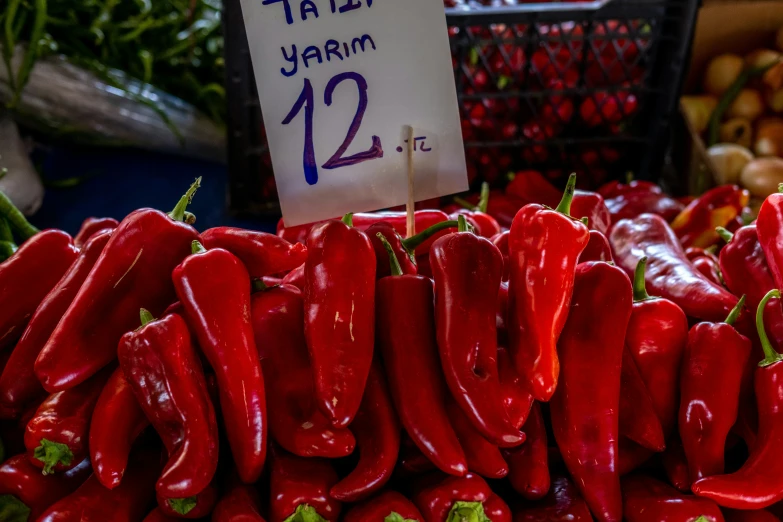 many red  peppers for sale at a farmers market