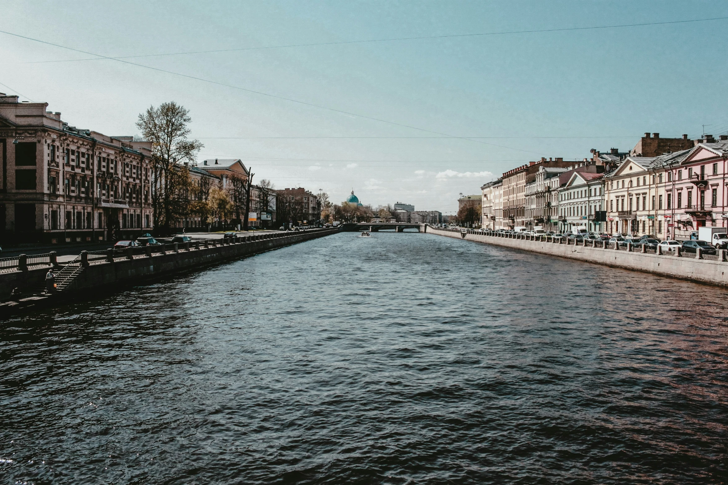 buildings line the side of a canal in a small town