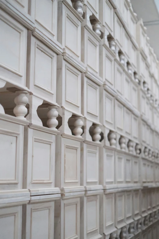 a wall covered with white wooden drawers