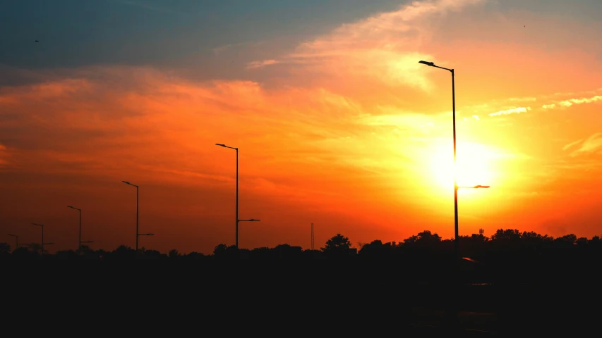 the setting sun, overcast skies, with street lamps in front