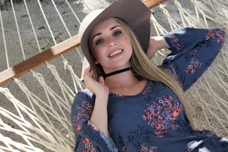 a woman wearing a cowboy hat while posing for a po