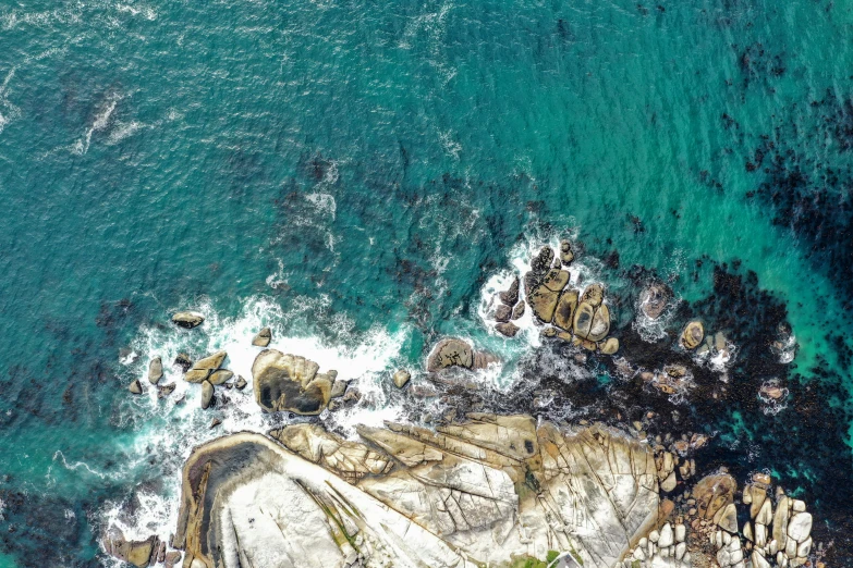 an aerial view of a rocky beach next to the ocean