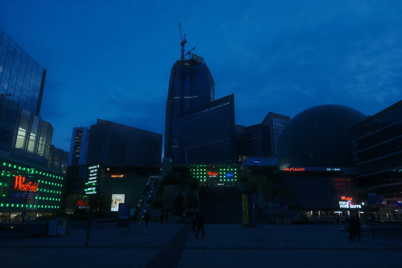 an empty plaza has people walking in it