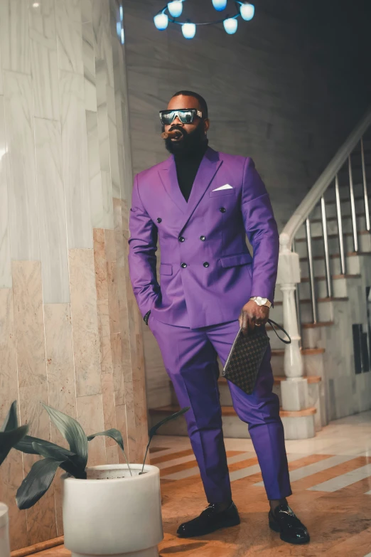 a man in a purple suit and a black mask posing for a pograph