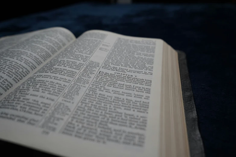 open book on a dark velvet surface with a blurry background