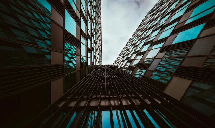 two buildings, one taller, against a cloudy sky