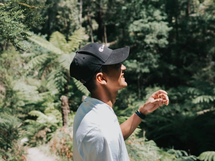 a young man stands in the forest holding out his hand