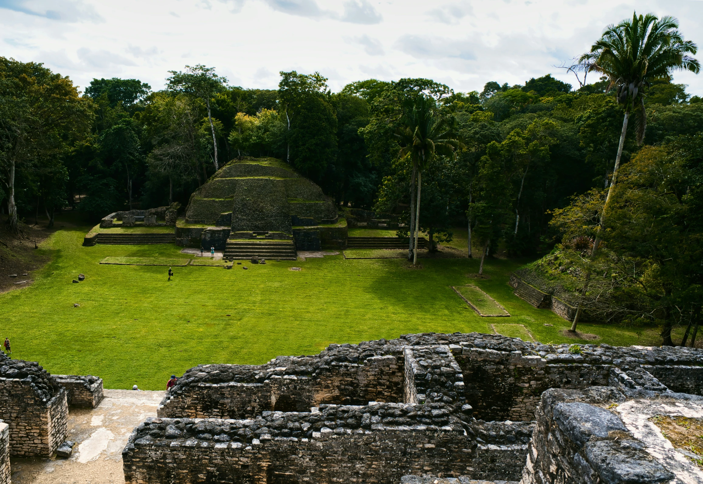 an ancient building surrounded by grass, trees, and other terrain