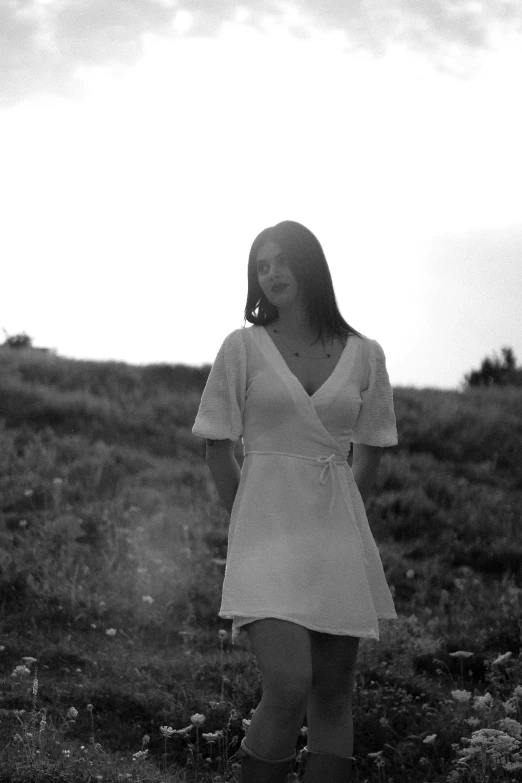 a woman standing in the middle of a grassy field