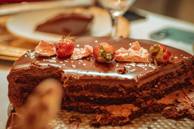 a chocolate cake with strawberries on top, sitting on a plate