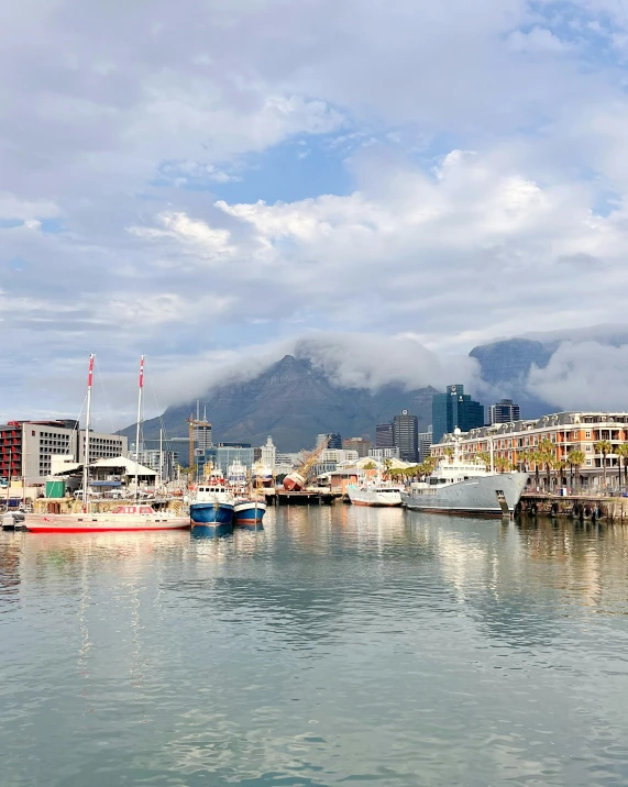 a harbor with many boats and mountains in the background