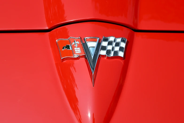 an emblem on a red car shows the red trim and the silver arrows