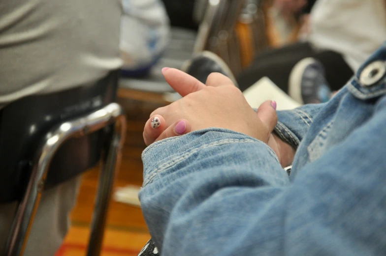 a woman with pink nail polish holding onto her cellphone