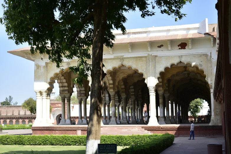 a big building with arches and some plants