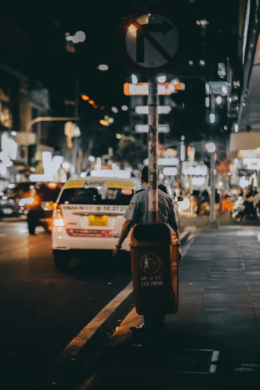 a man rides his bike on the sidewalk at night