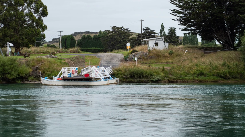 a boat floating on a river next to a road