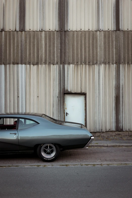 a grey car sits on the road next to a building