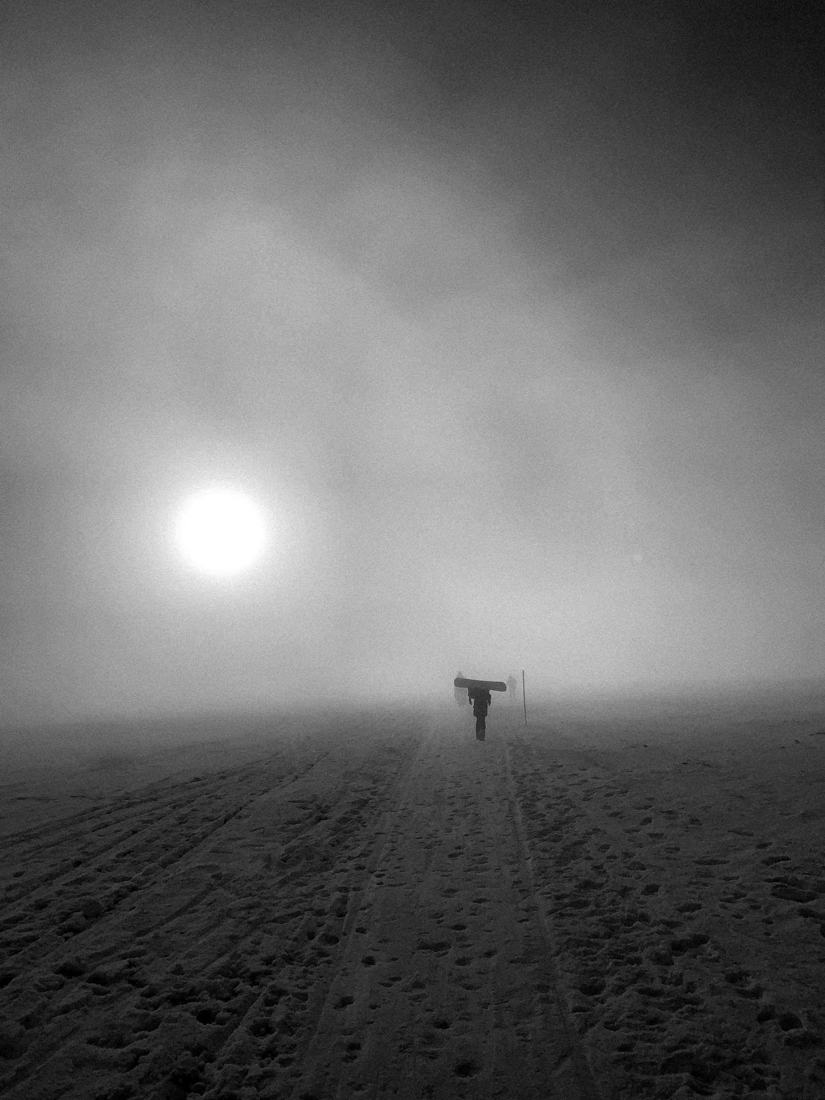 a person walking through the snow on a gloomy day