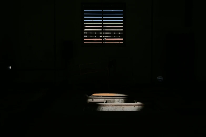 a bed in the dark with blinds on it