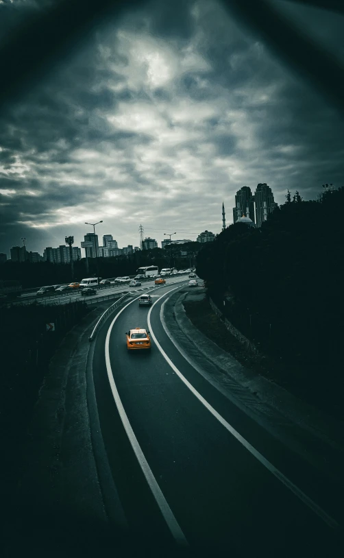 a car is driving down the highway with a lot of dark clouds