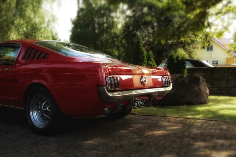 a car parked on a brick driveway with trees in the background