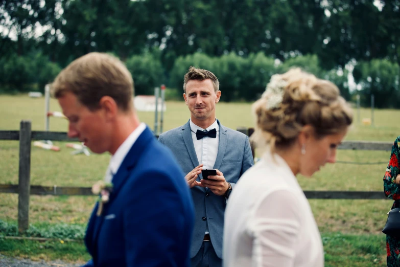 a bride and groom smile at the camera as they stand near an equestrian park