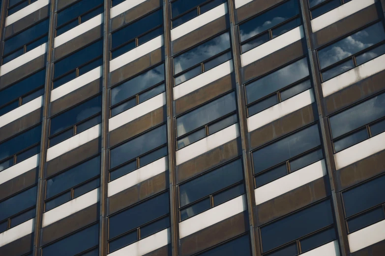 the windows are reflecting sky and clouds in them