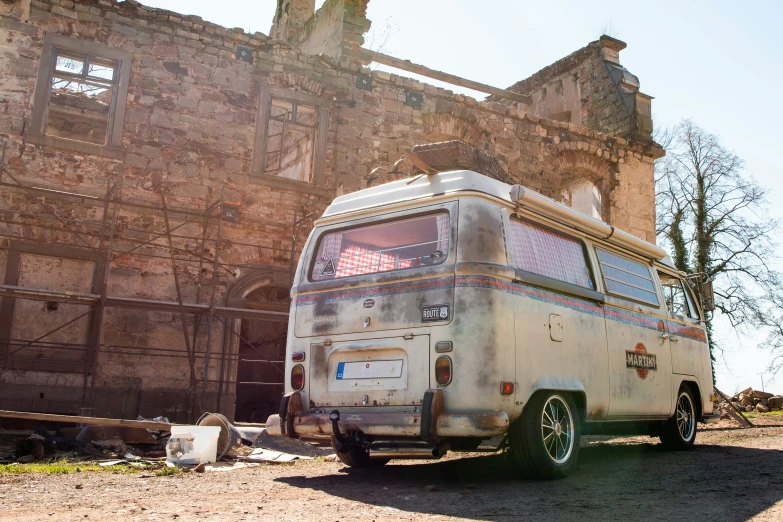 an old van is parked in front of a run down building