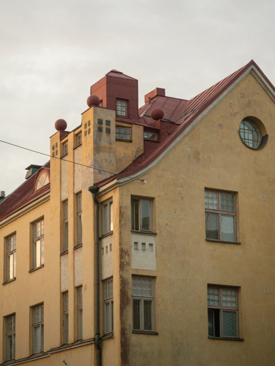 this is an old yellow building with many windows and roofs