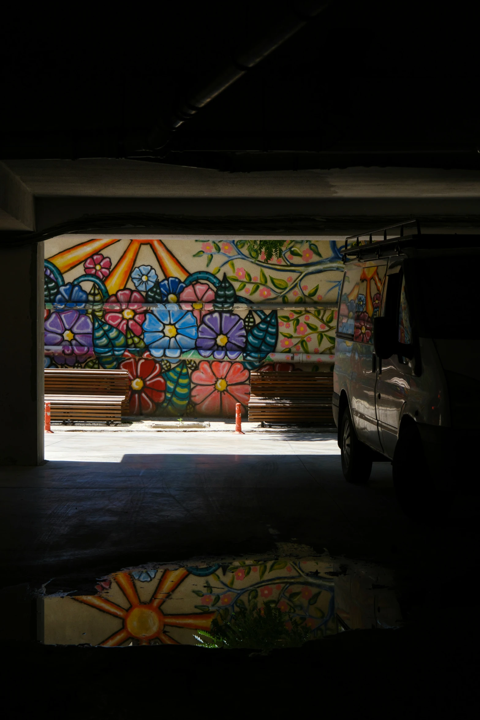 there is a bench under an overpass in a parking garage