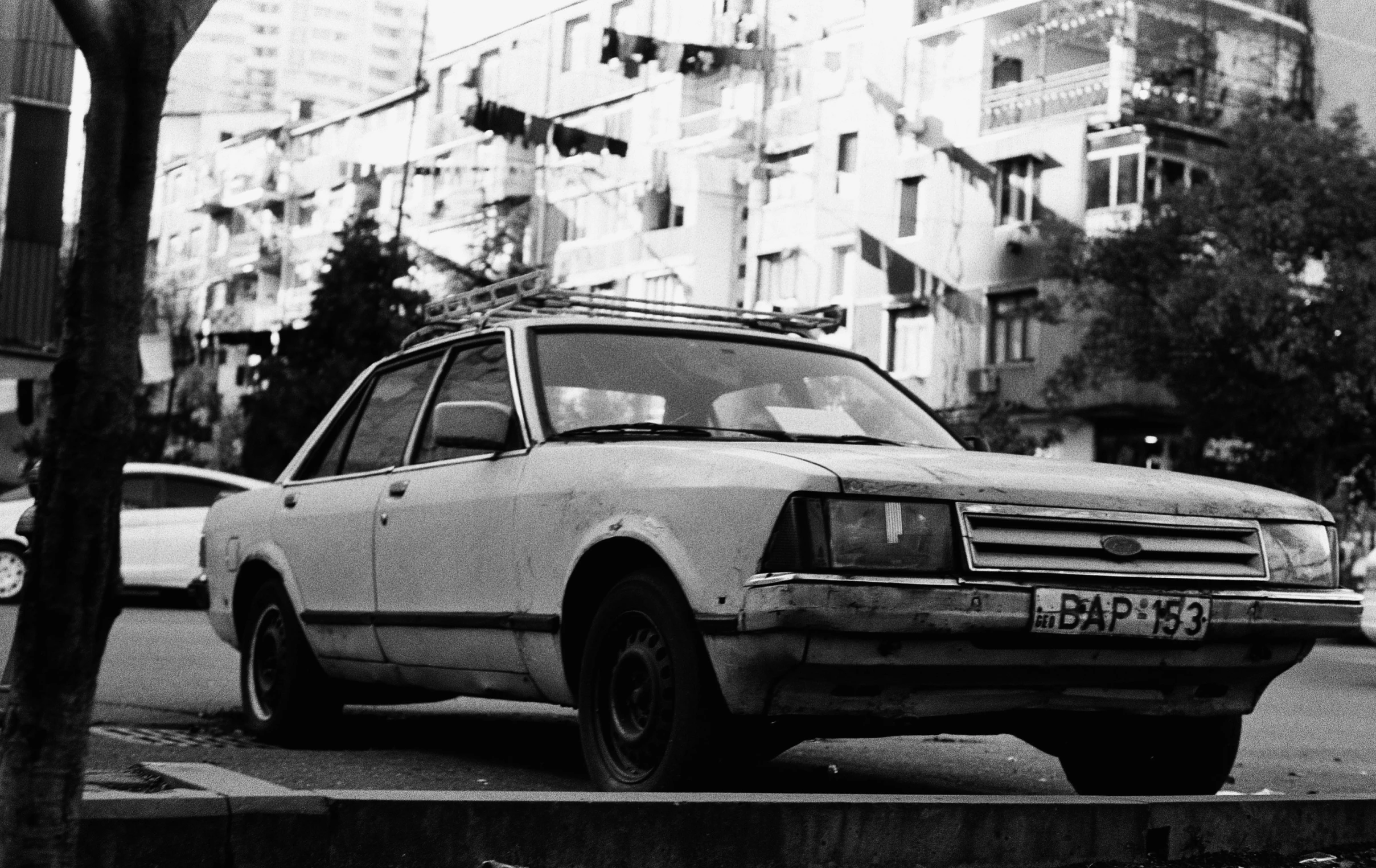 a car parked on the side of the road in front of some buildings