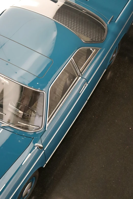 an older blue car that has a stripe design on the front
