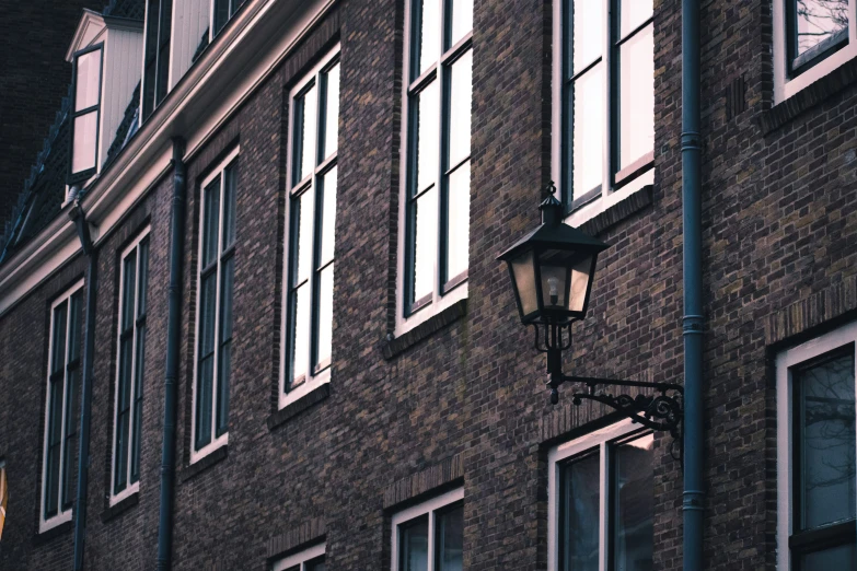 a lamppost with a clock is sitting outside of an old building