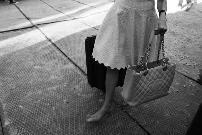 a woman in a dress standing with her suitcase