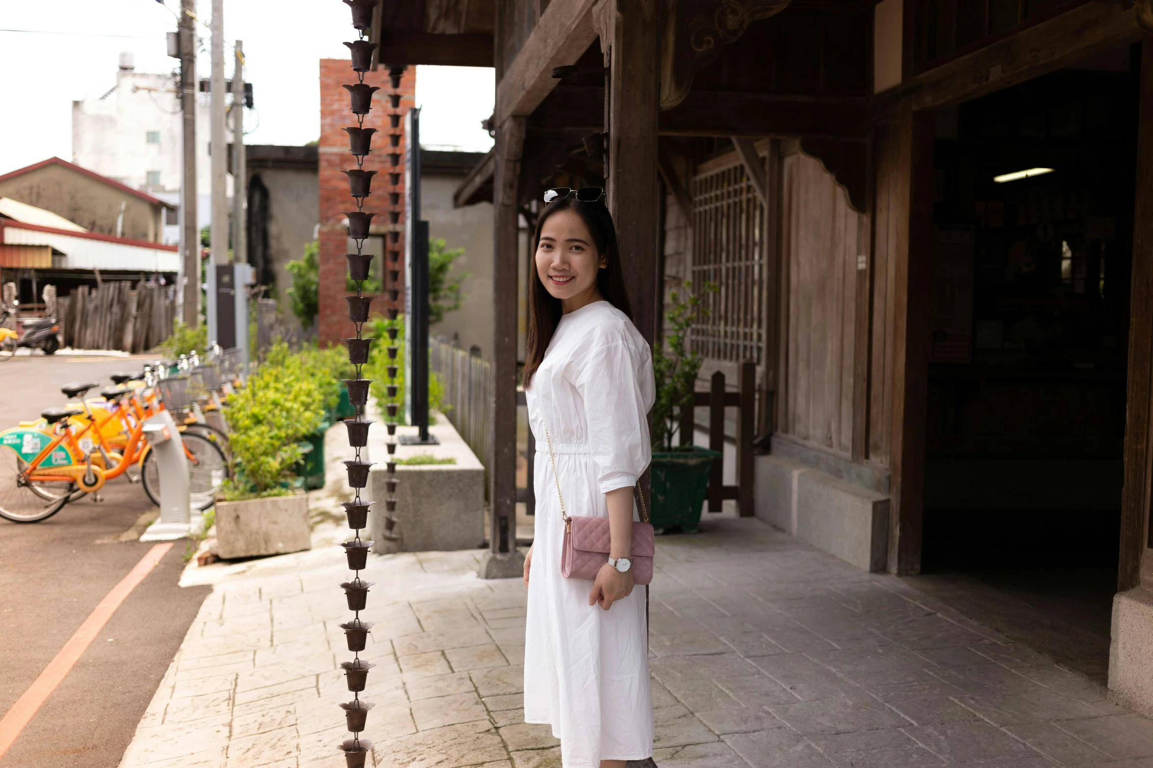 a woman standing outside by some wooden fence