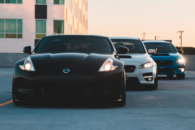 a group of cars driving down a road next to a building