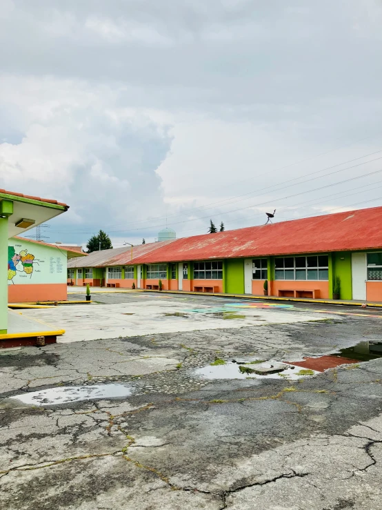 a green and yellow building with two small buildings