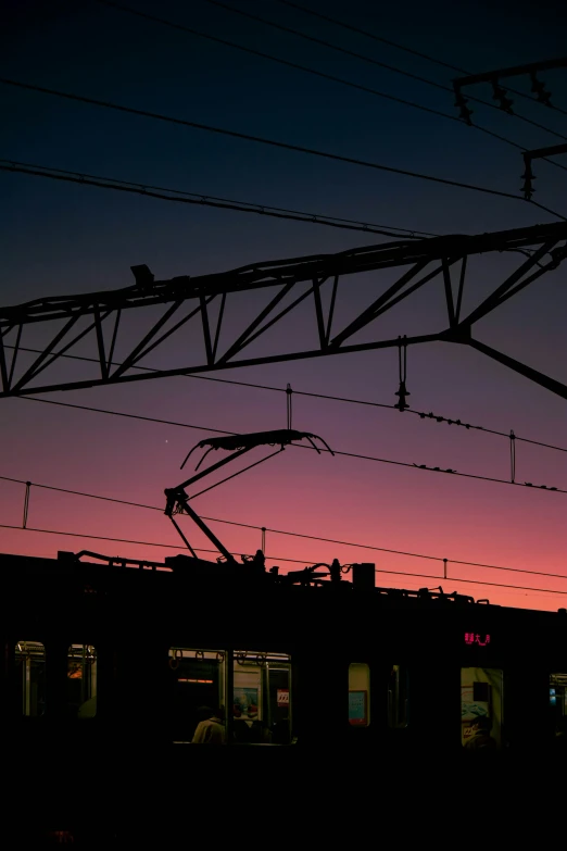 a dark scene with high voltage wires at sunset