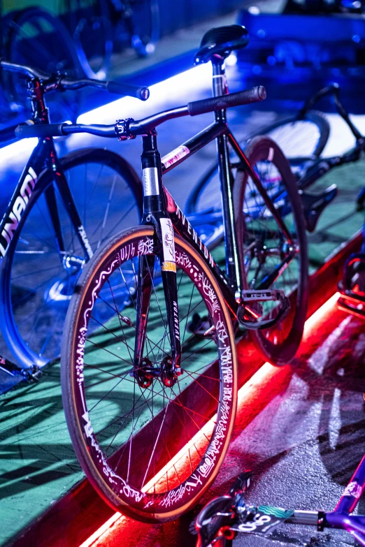 a bike sitting up against a red wall next to a row of bikes