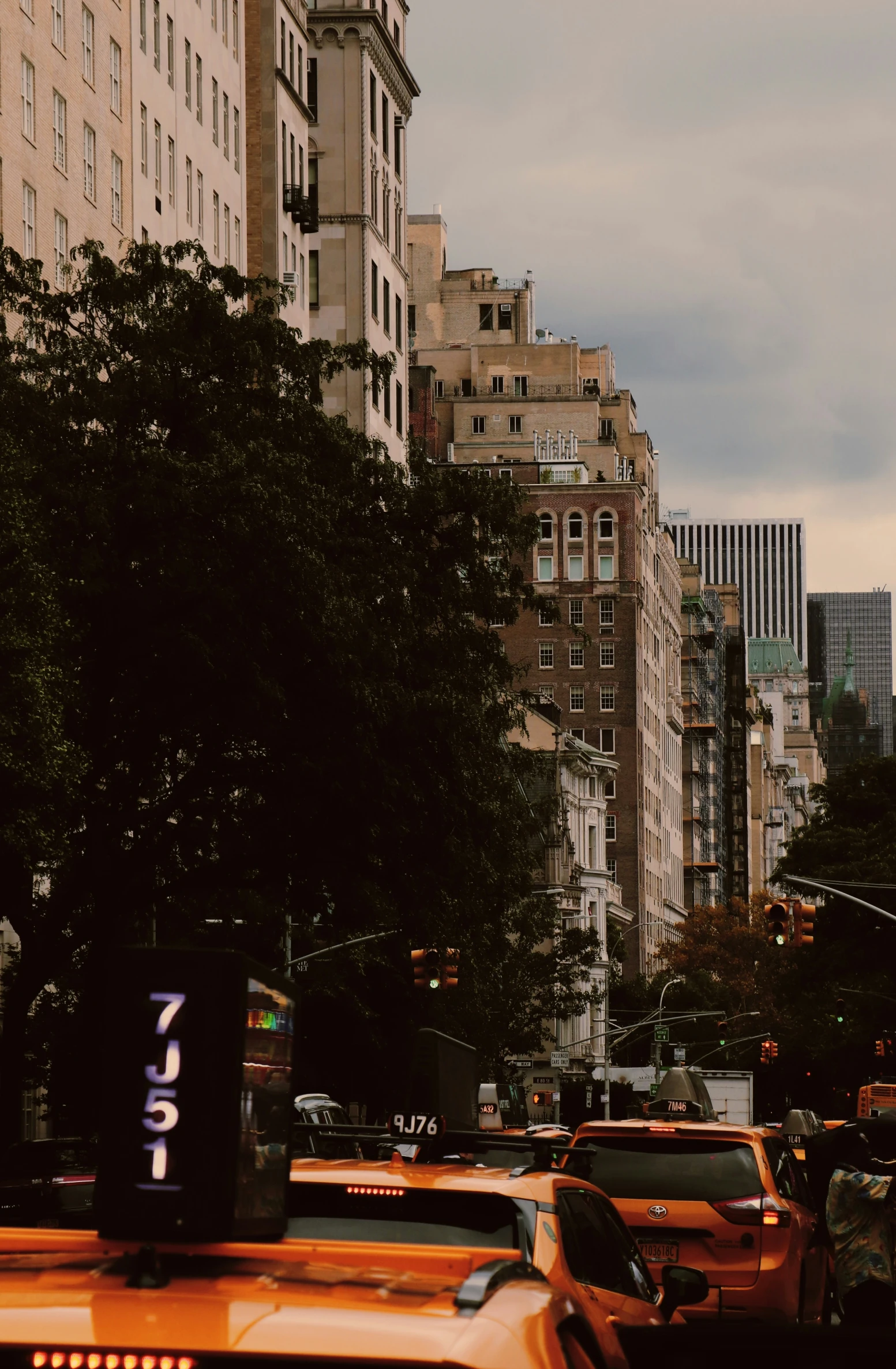 taxis on a busy city street near a tall building